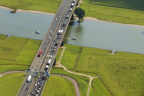 Road with traffic in a landscape with water