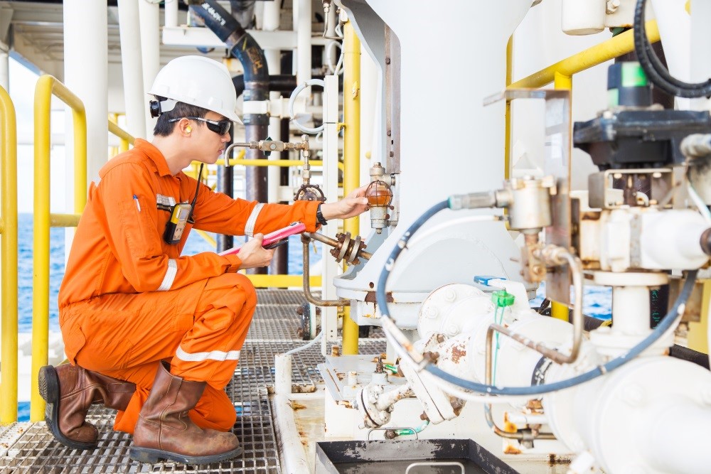 Kiwa engineer inspecting machinery on an oil, gas and chemicals platform
