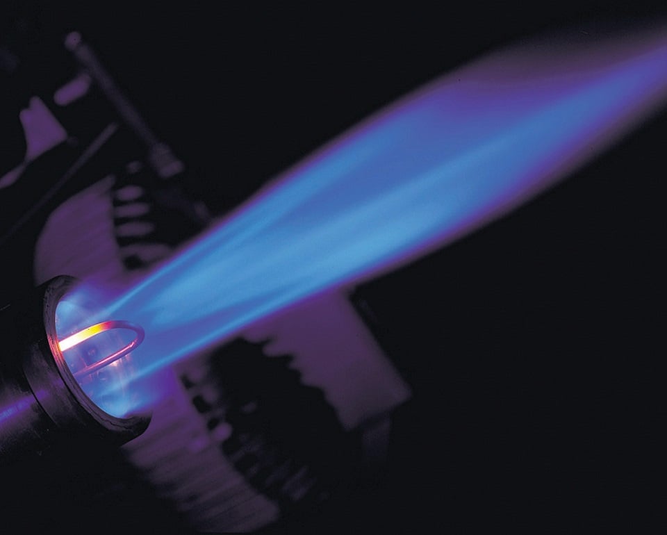 Blue gas flame from a torch burner with a dark background