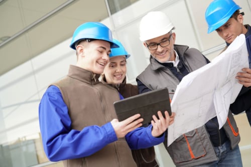 Workers are looking at a report on a food safety training as ones provided by Kiwa.