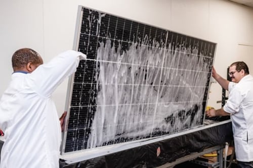 two kiwa specialists doing a module test on a solar panel
